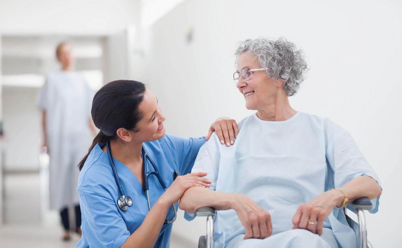 Médecin qui accompagne une personne âgée en chaise roulante